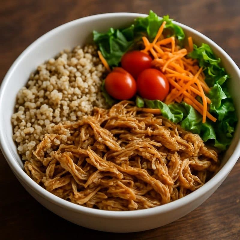 Bowl de quinoa con pollo mechado, vegetales y ensalada