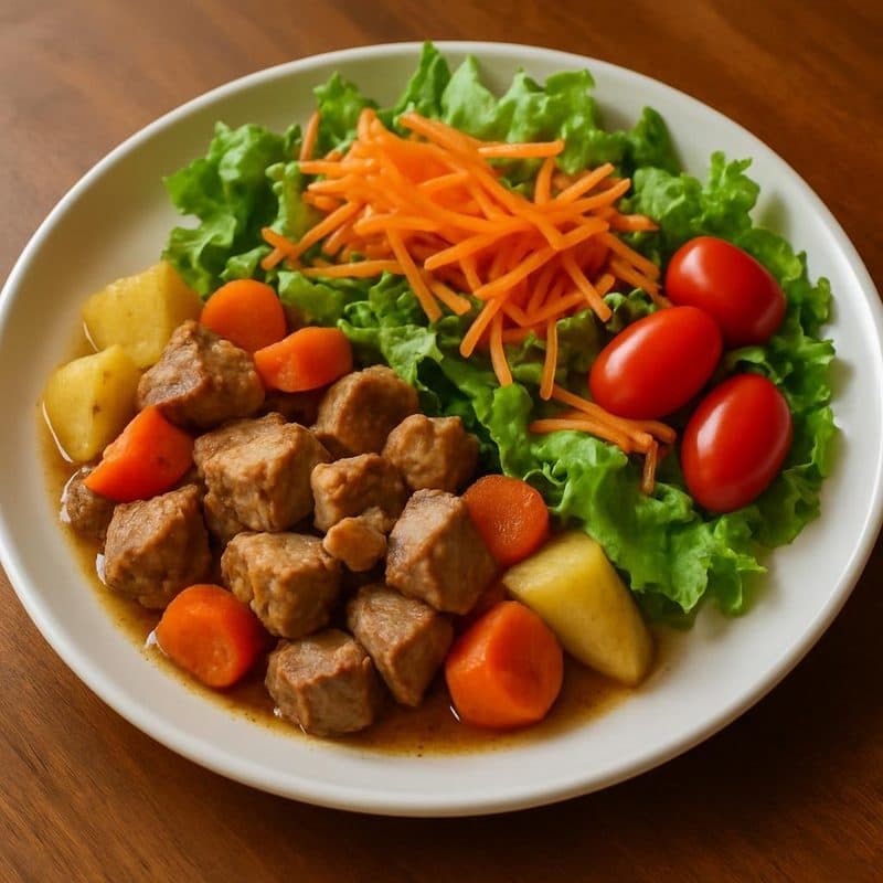 Trocitos de cerdo acompañados con papa, zanahoria y ensalada