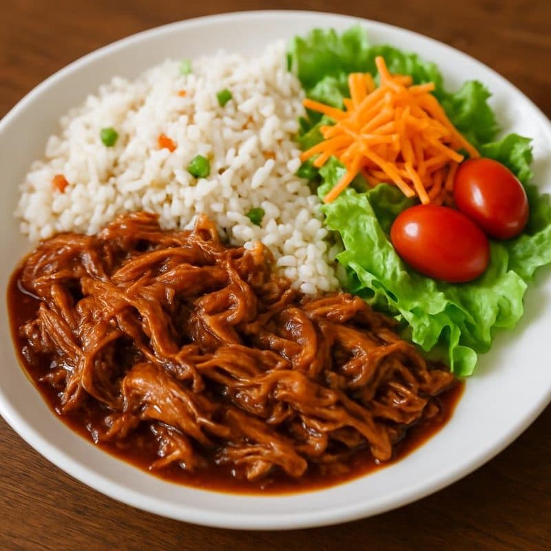 Cerdo mechado en salsa BBQ acompañado de arroz blanco jardinero y ensalada